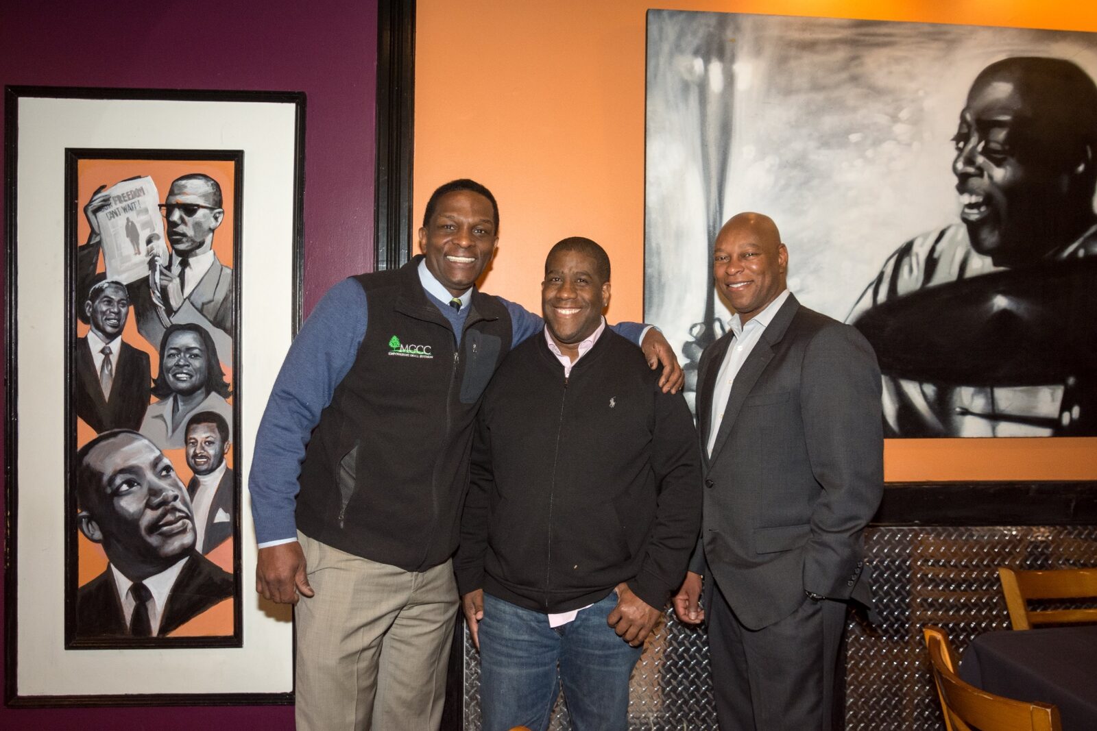 Shawn B. Hunter with two business partners in front of the jazz and civil rights murals at Slade's Bar and Grill in Boston